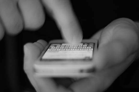 Finger tippt eine Nachricht auf einem Handy