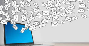 Gezeichnete Mail-Umschläge fliegen aus einem Notebook 