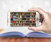 Smartphone mit Büchern auf dem Display über einem Buch