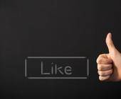 Ein Like-Button und eine Hand mit hochgestrecktem Daumen