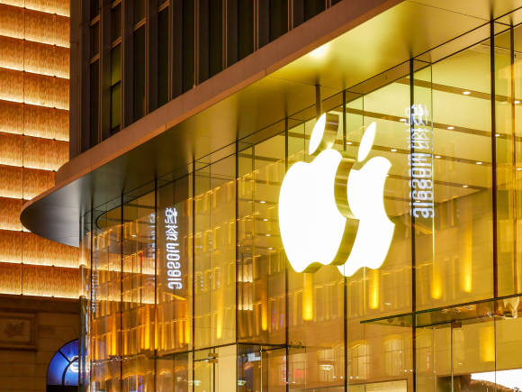 Leuchtendes Apple-Logo an einer Glas-Fassade 