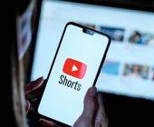 Person hält Smartphone mit Youtube Shorts App Logo