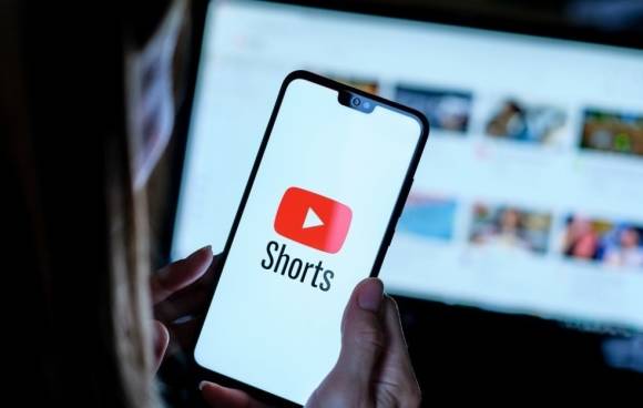 Person hält Smartphone mit Youtube Shorts App Logo 