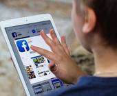 Junge nutzt Facebook auf dem Tablet