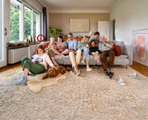 Mehrere Personen auf einem Sofa und ein rotes Quckline-Q im Hintergrund 