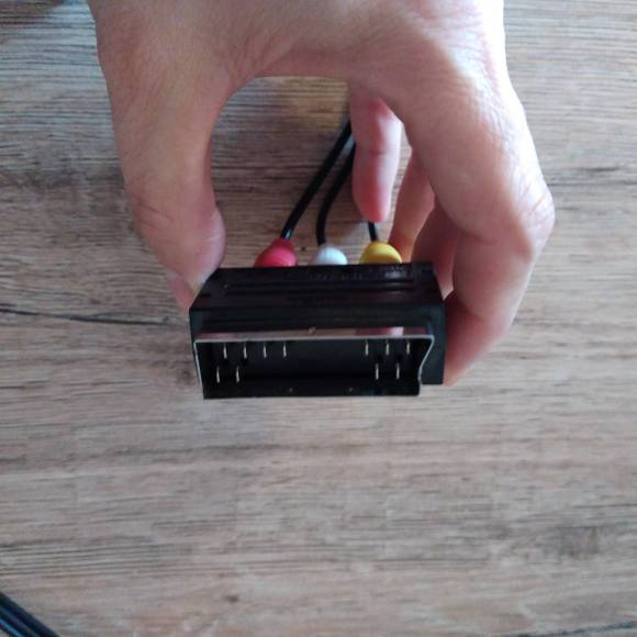 Eine Hand hält den Scart-Adapter