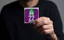 Person hält eine Autobahnvignette in der Hand Person hält eine Autobahnvignette in der Hand