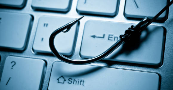 Symbolbild zeigt Anglerhaken auf einer Tastatur 