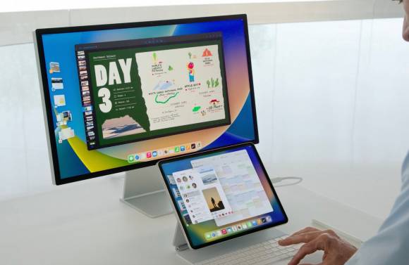 Das Foto zeigt ein iPad mit Tastatur, das über ein Kabel mit einem Display verbunden ist