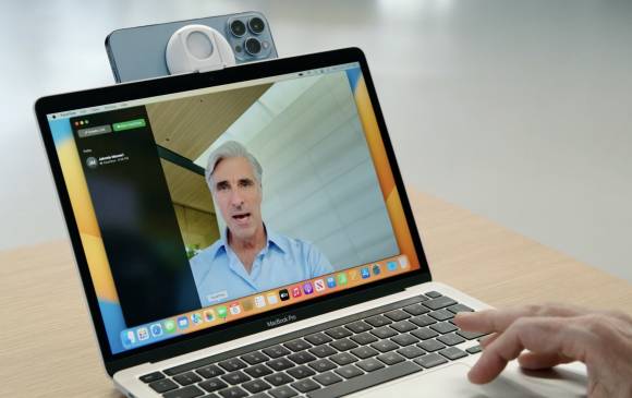 Das Foto zeigt ein MacBook Pro, an dessen Display ein iPhone als Webcam montiert ist