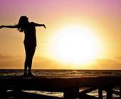 Symbolbild zeigt Silhouette einer Frau im Sonnenuntergang