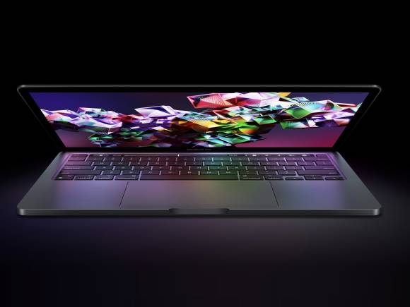 Das Foto zeigt ein halb geöffnetes MacBook Pro vor einem schwarzen Hintergrund 