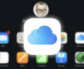 Vor einem unscharfen Hintergrund mit Symbolen steht das Symbol für Apples iCloud