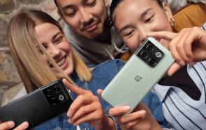 Drei lachende junge Menschen mit One-Plus-Smartphones 