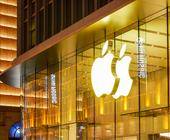 Beleuchtetes Apple-Logo an einer Glas-Gebäudefassade