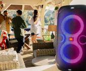 Im Vordergrund eine JBL Partybox 110, im Hintergrund tanzende Menschen