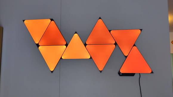Die Triangles an der Wand, orange leuchtend