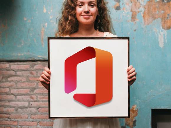 Office ist für viele Bildformate offen – aber nicht alle sind gleichermassen gut geeignet Eine junge Frau steht vor einer etwas verwitterten Mauer; in ihren Händen hält sie ein Bild mit dem Logo von Microsoft Office