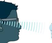 Schema zeigt Schallwellen zwischen dem Ohr des Hörgeräteträgers und dem Gesicht einer Person mit Hygienemaske