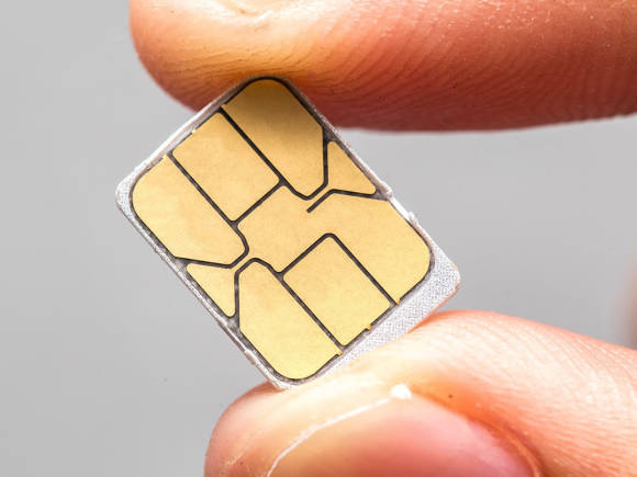 Eine Nano-SIM-Karte, die zwischen Daumen und Zeigefinger gehalten wird 