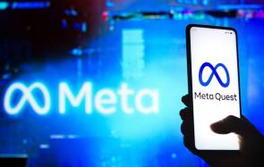 Ein Smartphone mit Meta Quest Logo, im unscharfen Hintergrund das Meta-Logo 