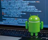 Ein Android-Roboter steht neben einem Notebook mit Quellcode