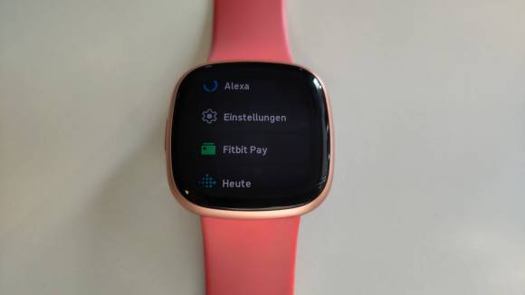Eine Fitbit mit rotem Armband. Im Menü ist nur Fitbit Pay zu sehen, Google Wallet fehlt noch