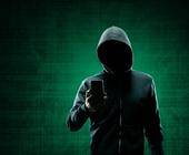 Krimineller mit Hoodie und einem Smartphone