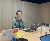 Daniel Fabian sitzt an einem Tisch an seinem Notebook