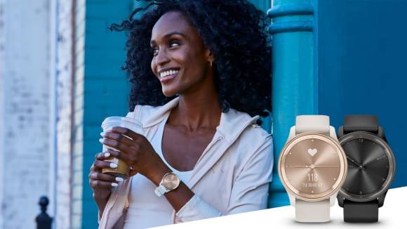 Eine Frau, die lachend einen Kaffeebecher hält, trägt eine Garmin Vivomove Trend 