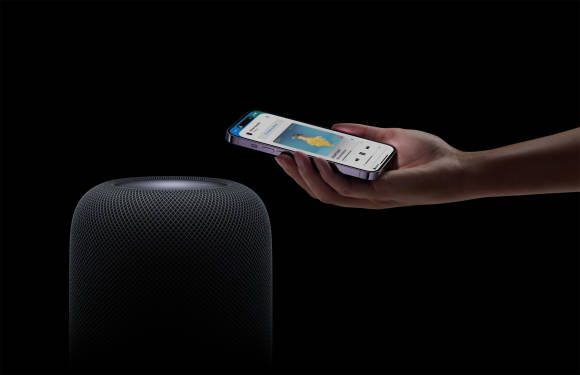 Immer wieder elegant: Durch eine Annäherung des iPhones wird die Ausgabe umgeleitet Ein iPhone wird nahe an den HomePod gehalten