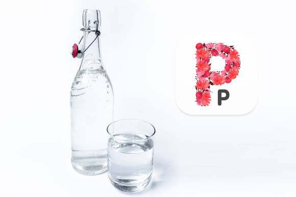 Glasflasche und Trinkglas mit klarem Wasser, im Vordergrund das Programmsymbol von Pure Paste 