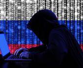 Symbolbild eines Hackers mit Hoodie vor einer russischen Flagge