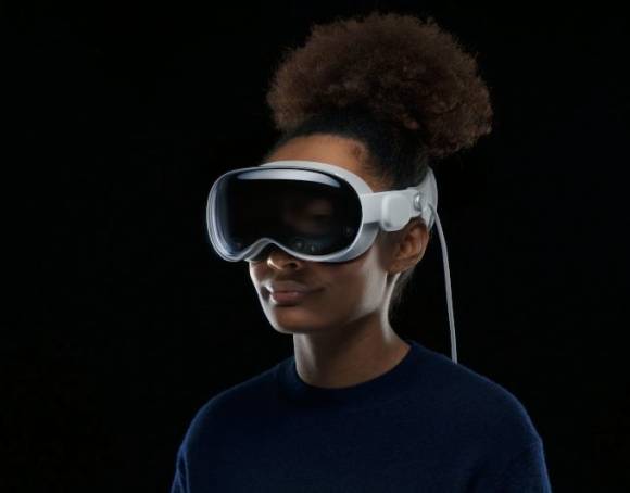 Eine Frau trägt die Apple Vision, die ein wenig wie eine verkabelte Ski- oder Taucherbrille aussieht 
