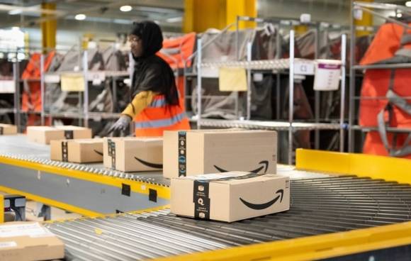 Pakete mit Amazon-Logo auf einem Förderband 