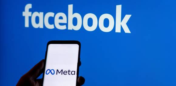 Facebook-Logo und ein Smartphone mit Meta-Logo 