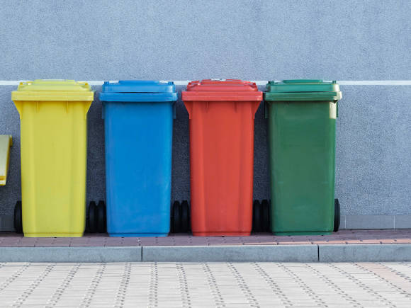Vier Mülltonnen in einer Reihe 