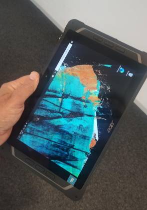 Das eingeschaltete Tablet, in der Hand gehalten