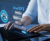 Person an einem Notebook und ein ChatGPT-Fenster