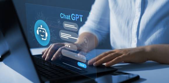 Person an einem Notebook und ein ChatGPT-Fenster 