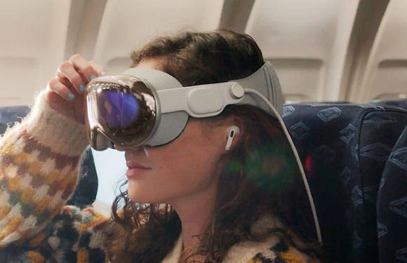Eine Frau trägt im Flugzeug eine Vision-Pro-Brille