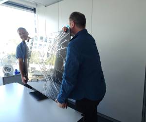2 Männer platzieren den Samsung-TV auf einem Tisch