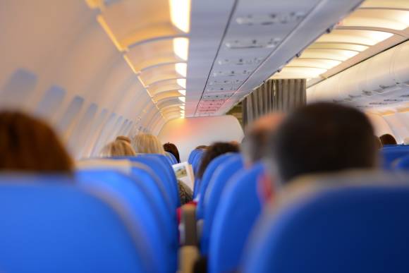 Passagiere, die in einem Flugzeug sitzen, von hinten fotografiert 